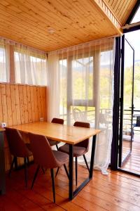 a dining room with a wooden table and chairs at Zholovani Cottages in Lagodekhi +13 photos