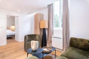 a living room with a couch and a chair at La Maison Bretzel & SPA Medipole - Climatisé in Villeurbanne
