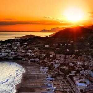 a city with the sun setting over the ocean at Gaeta, vicino al mare in Gaeta