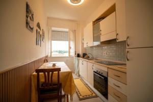 a small kitchen with a table and a refrigerator at Casa Margherita in Vimercate