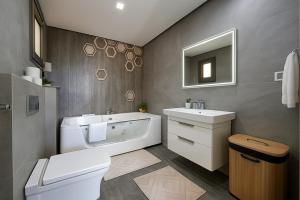 a bathroom with a tub and a sink and a toilet at Luxury 2 Bedroom Apartment Menzah 9C Near the airport in Tunis +10 photos