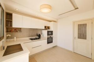 a white kitchen with white cabinets and a door at Luxury 2 Bedroom Apartment Menzah 9C Near the airport in Tunis