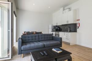 a living room with a blue couch and a table at Downtown 1 Bedroom Apartment E - 150m from the Beach in Albufeira