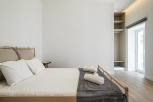 a bedroom with a bed with white sheets and a window at Downtown 1 Bedroom Apartment E - 150m from the Beach in Albufeira
