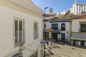 a group of people walking down a street between two buildings at Downtown 1 Bedroom Apartment E - 150m from the Beach in Albufeira