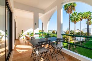 un balcone con un tavolo nero, sedie e palme di Casa Alonso 2 Bedroom Apartment with Pool a Branqueira