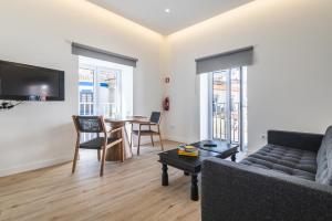 a living room with a couch and a table at Downtown Studio Apartment F - 150m from the Beach in Albufeira