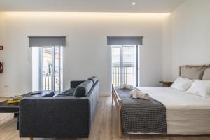 a living room with a bed and a couch at Downtown Studio Apartment F - 150m from the Beach in Albufeira