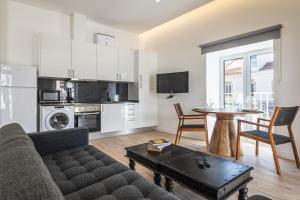a living room with a couch and a table at Downtown Studio Apartment F - 150m from the Beach in Albufeira