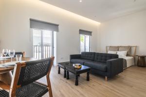 a living room with a couch and a table at Downtown Studio Apartment F - 150m from the Beach in Albufeira +21 photos