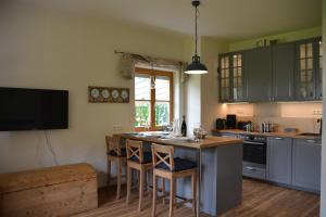 eine Küche mit einer Insel mit Barhockern in der Unterkunft Chiemsee Beachhouse Apartment in Bernau am Chiemsee