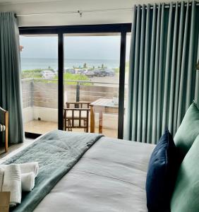 Un dormitorio con una cama con vista al mar. en AtSupers Accommodation, en Jeffreys Bay