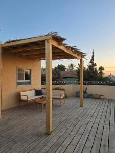 a wooden deck with a pergola on a house at על הגג במדבר in Mitzpe Ramon
