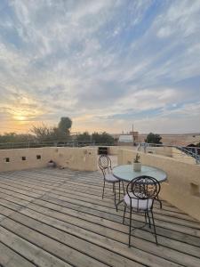 a patio with two chairs and a table on a deck at על הגג במדבר in Mitzpe Ramon