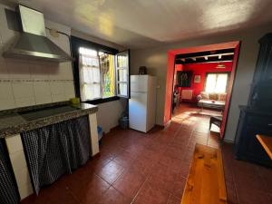 a kitchen with a white refrigerator and a red door at Casa Lula 2 Pendueles Llanes AR-685-AS in Llanes