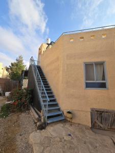 a staircase leading to the side of a building at על הגג במדבר in Mitzpe Ramon