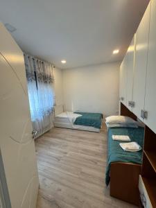 House 31 Plus في مونفالكوني: غرفة صغيرة بسريرين وممر