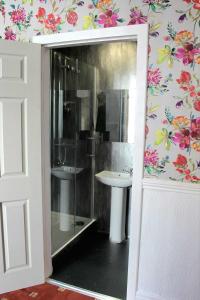 a bathroom with a shower and a sink at Belroy Hotel in Blackpool