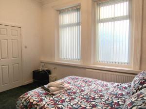 a person laying on a bed in a room with windows at Belroy Hotel in Blackpool