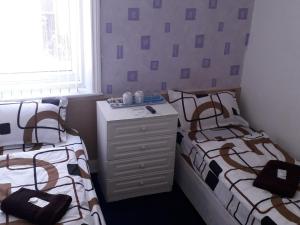 ein Schlafzimmer mit zwei Betten und einer Kommode in der Unterkunft Belroy Hotel in Blackpool