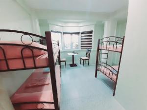 a room with two bunk beds and a table at Avana Hills Boracay Prime Horizon Suite 103 in Boracay