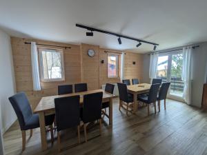 a dining room with tables and chairs and a clock at Meije 11 a1 in Les Deux Alpes