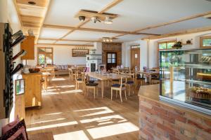 a restaurant with tables and chairs in a room at Kaffeekandl Café & Pension in Glonn