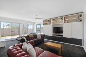 a living room with a couch and a tv at The Summer Residence Middleton in Middleton