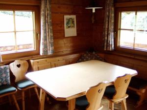 a dining room with a white table and chairs at Moaralmhütte in Görtschach