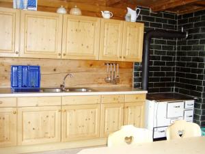 a kitchen with wooden cabinets and a sink at Moaralmhütte in Görtschach