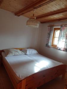 a bedroom with a bed with a wooden frame and a window at Moaralmhütte in Görtschach