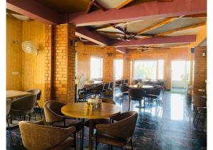 a restaurant with tables and chairs in a room at The Aesthetic Hotel & Restaurant in Bhīm Tāl