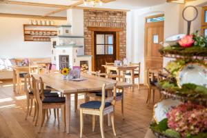 a dining room with a wooden table and chairs at Kaffeekandl Café & Pension in Glonn +3 photos