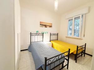 a bedroom with two beds and a window at Casabianca in San Vincenzo