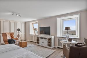 a bedroom with a bed and a flat screen tv at Hotel Strand No.1 in Sankt Peter-Ording