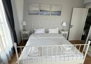una camera da letto con un letto bianco con due comodini di One-Bedroom Apartment in Caesar Blue Complex a Protaras Altre 2 foto