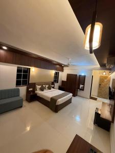 Un dormitorio grande con una cama y un sofá. en High Five Hotels, en Assagao