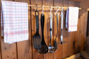a bunch of kitchen utensils hanging on a wall at Samerhaus in Hüttschlag