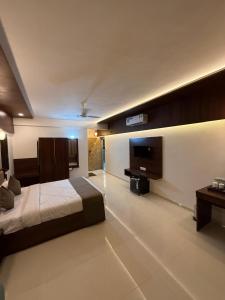 Un dormitorio con una cama y un televisor de pantalla plana. en High Five Hotels, en Assagao