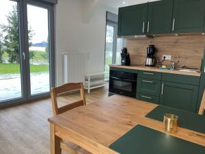 a kitchen with green cabinets and a wooden table at 4-Steine-Blick, Wohnung "Zur Kaiserkrone" in Schöna
