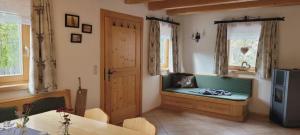 a living room with a green bench in a room at Rengerberg Hütte in Rengerberg +3 photos