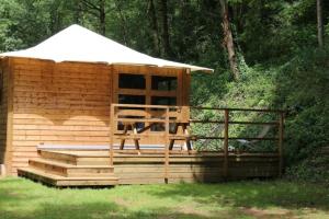 a wooden cabin with a gazebo at ZEcamping 3 étoiles avec piscine bar et restaurant en bord de ruisseau in Belguiral