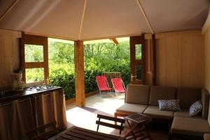 ein Wohnzimmer mit einem Sofa und zwei roten Stühlen in der Unterkunft Cabane 3 étoiles - Piscine - eec0cc in Belguiral