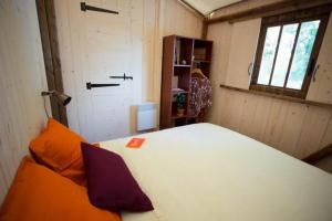 a small room with a bed and a window at ZEcamping 3 étoiles avec piscine bar et restaurant en bord de ruisseau in Belguiral +13 photos