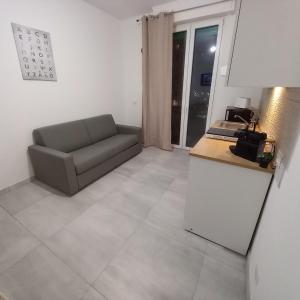 a living room with a couch and a kitchen at Case ieo - 200m da via Ripamonti Mi in Opera