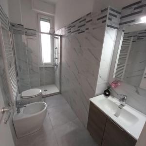 a white bathroom with a sink and a toilet and a shower at Case ieo - 200m da via Ripamonti Mi in Opera