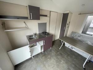 Una pequeña cocina con fregadero y mesa. en Chalet 3 étoiles - Piscine - ccbbgcc, en Sauxillanges
