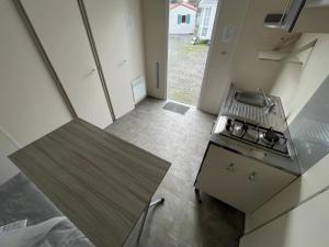 una pequeña cocina con fogones y encimera en Chalet 3 étoiles - Piscine - ccbbgcc, en Sauxillanges