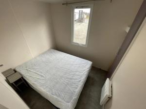 Habitación pequeña con cama y ventana en Chalet 3 étoiles - Piscine - ccbbgcc, en Sauxillanges