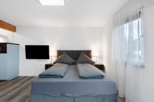 a bedroom with a bed with a flat screen tv at Motel Ambiente 1 - Luxus Studio in Bad Säckingen